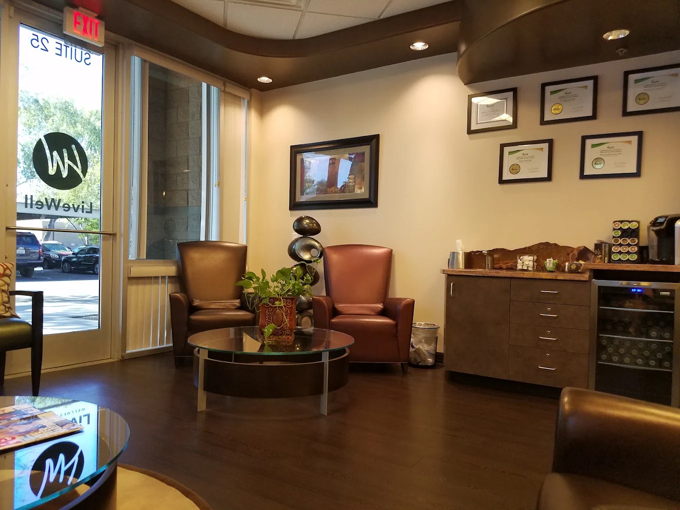 Waiting area with seating and framed credentials at Live Well Wellness Center in Chandler